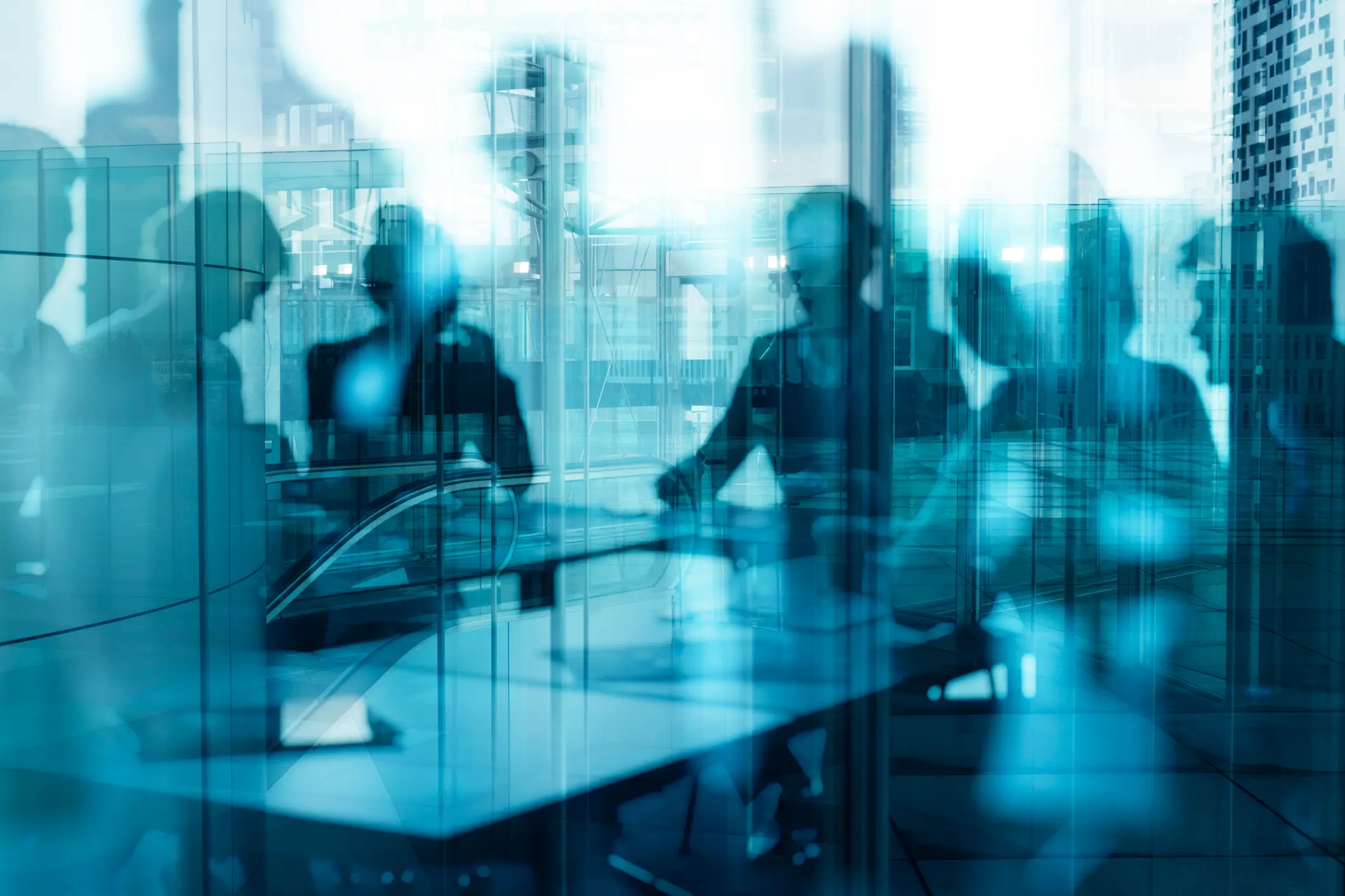 Silhouetted figures in a meeting room.